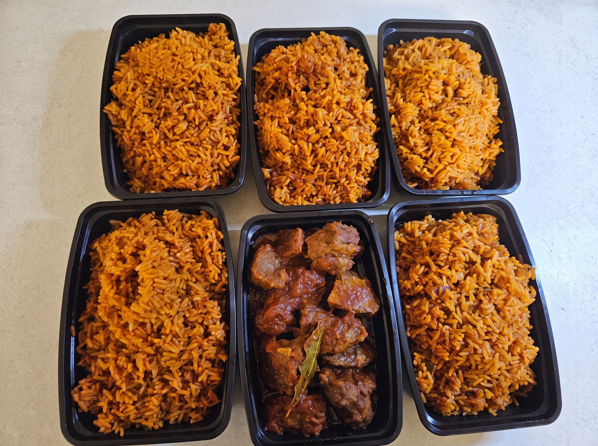 Party jollof rice and peppered beef packed for delivery