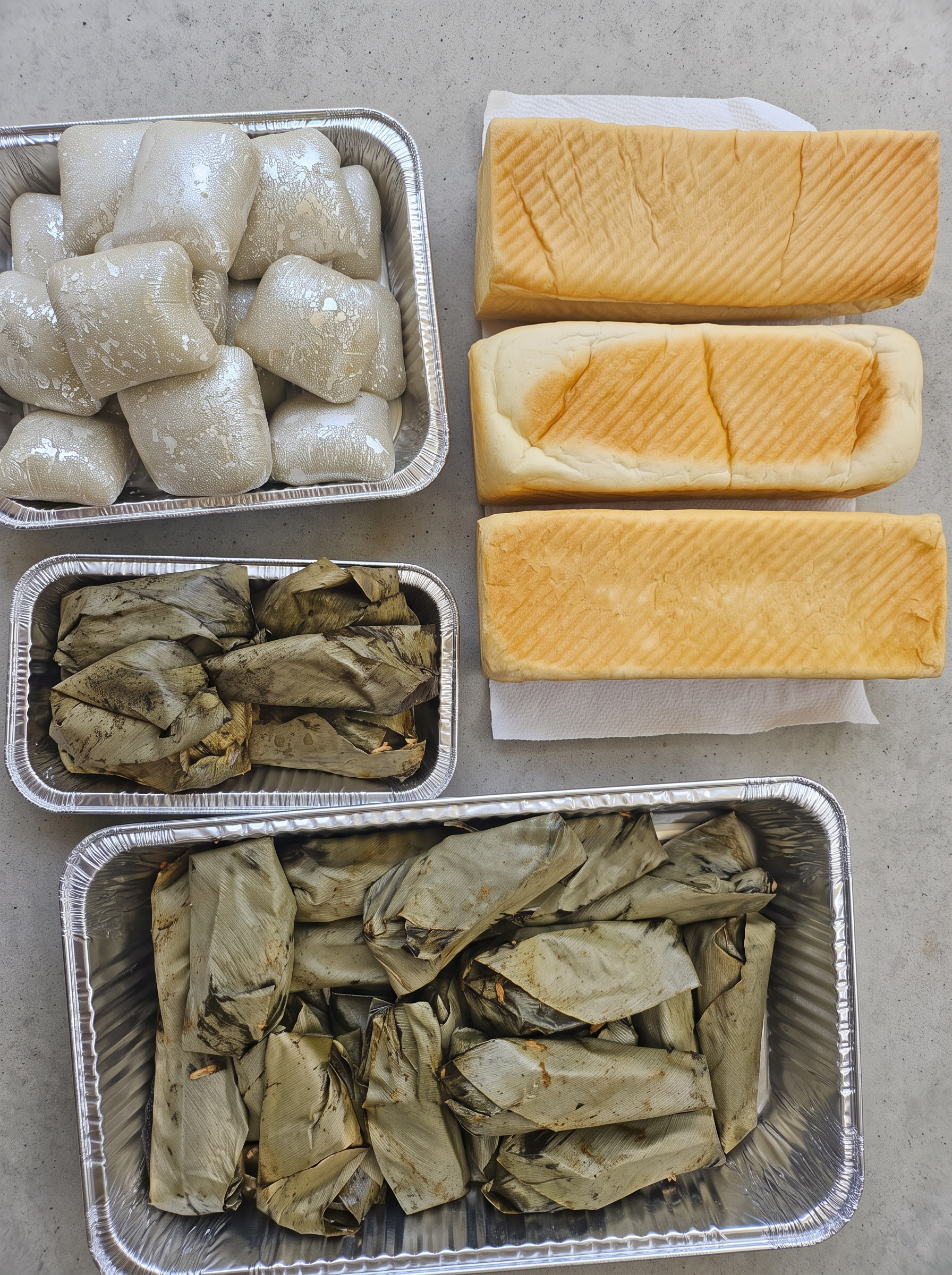 Leaf-wrapped moi moi, fufu portions and fresh bread loaves