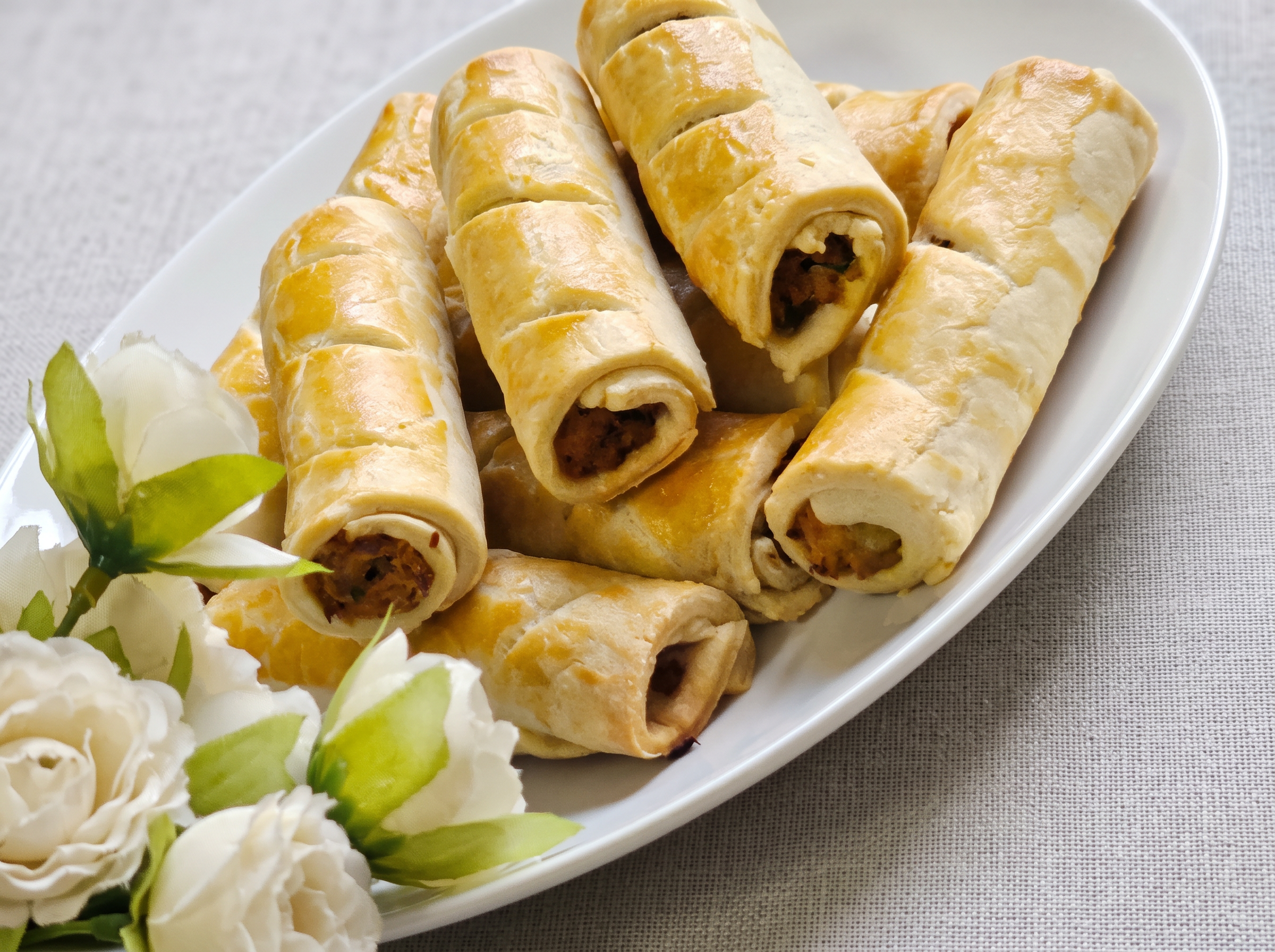 Freshly baked sausage rolls on a platter